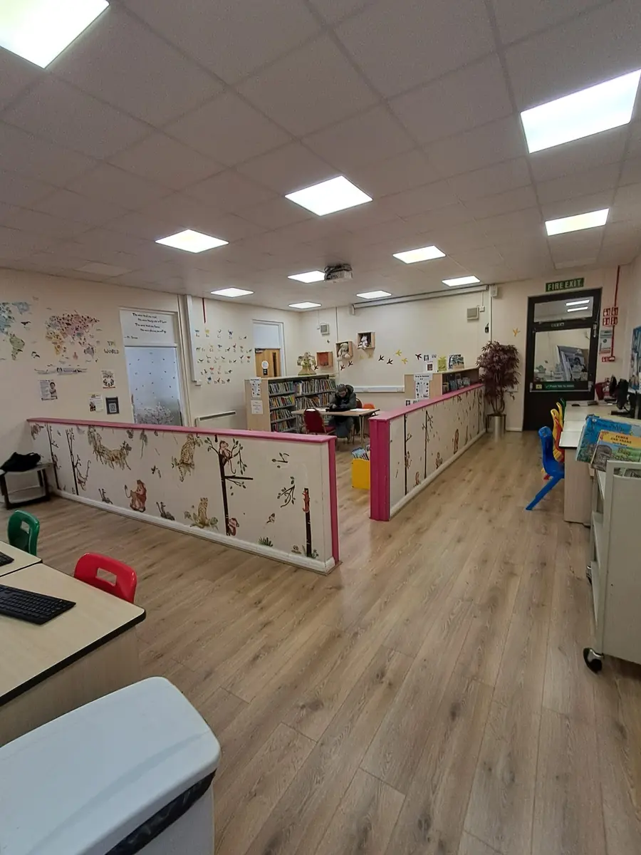 A teaching room with tables and stacking chairs set out for a class