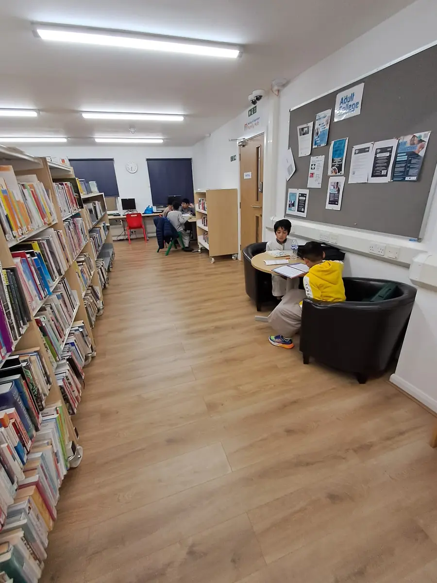 A room at the centre lined with bookshelves and noticeboards